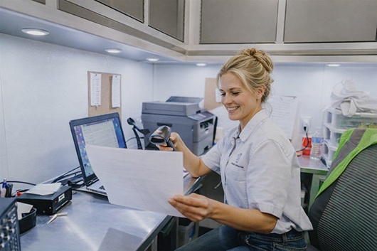 Female hearing technician operating computer