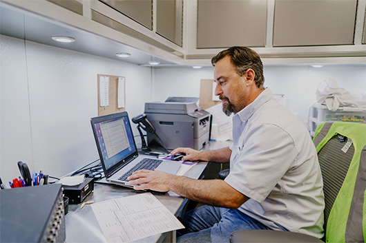 Male hearing technician operating computer